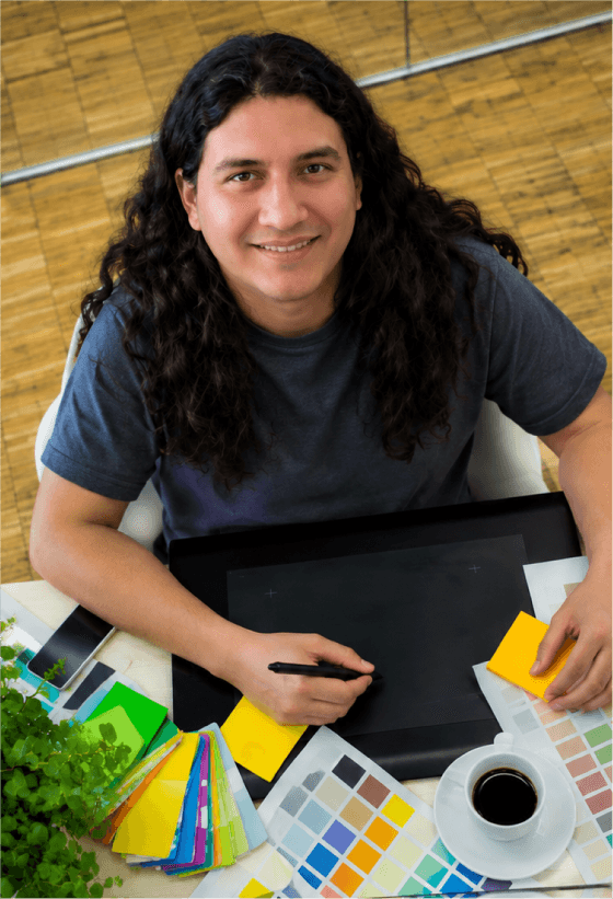 Jorge Acosta en su estudio, trabajando con tablet y paletas de color